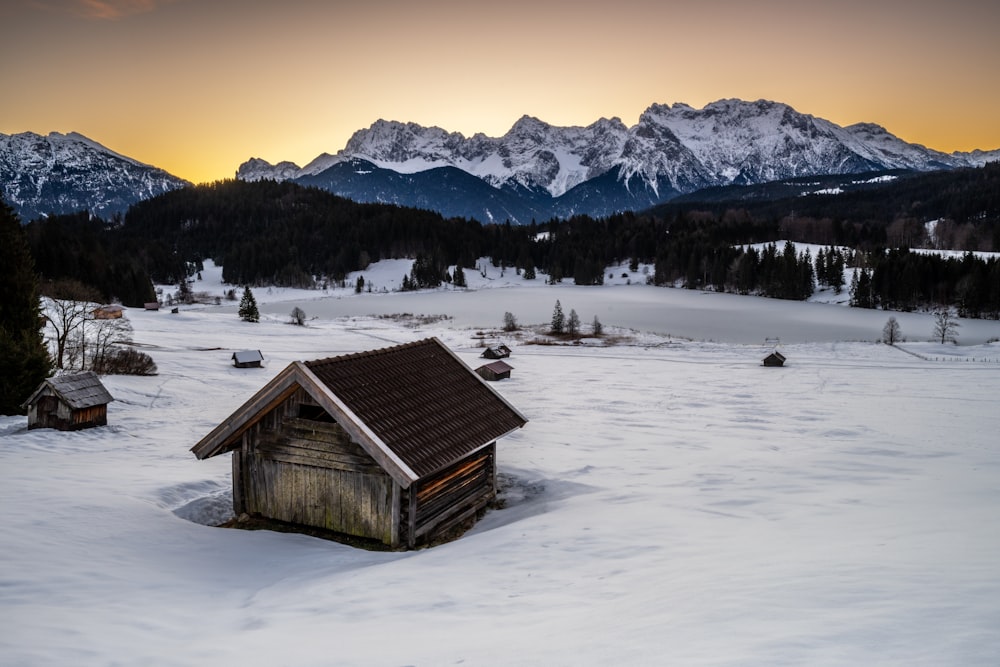 a small cabin in the middle of a snowy field