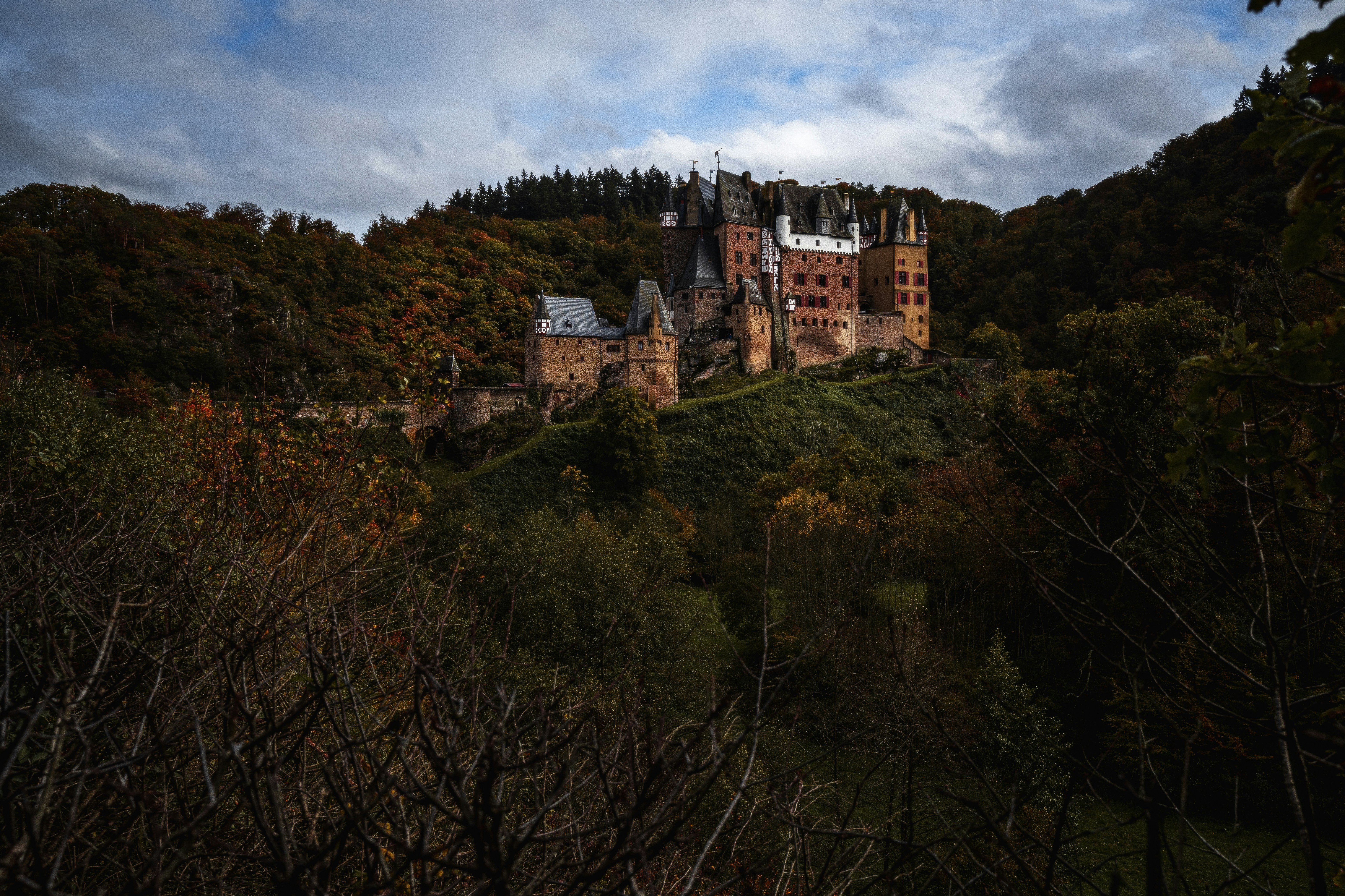 a large castle sitting on top of a lush green hillside