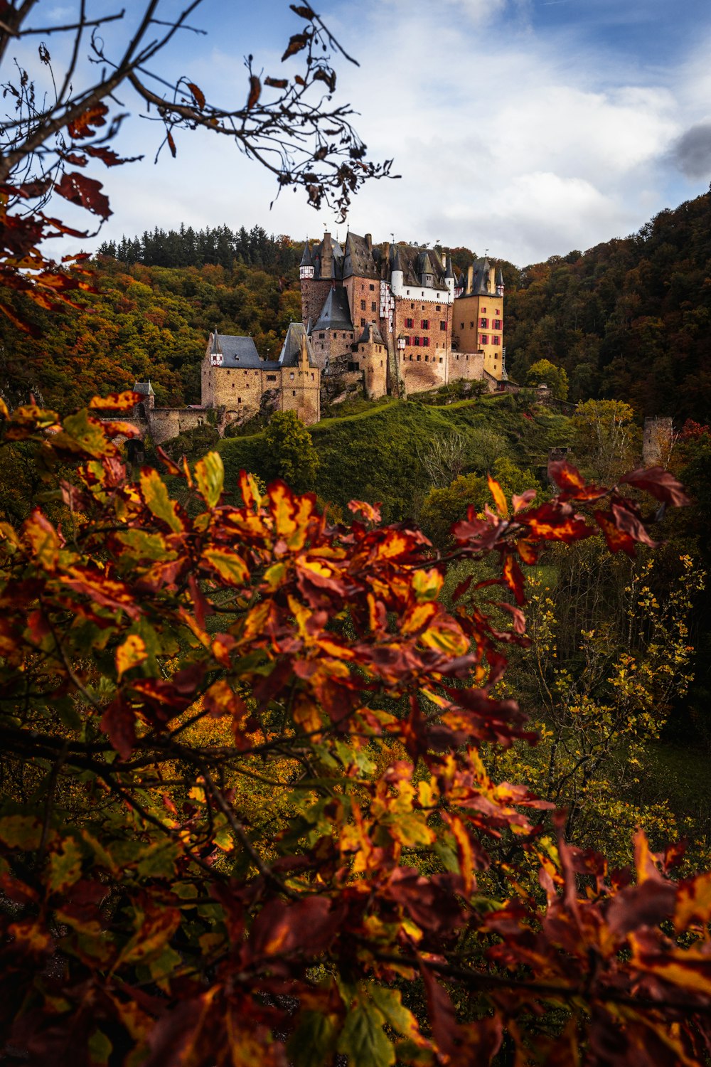 Un grand château assis au sommet d’une colline verdoyante