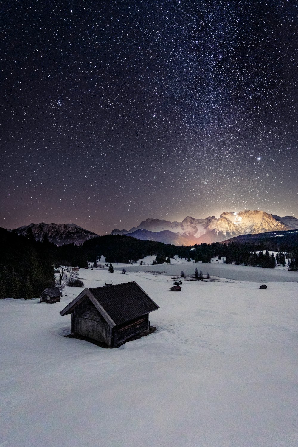 a cabin in the middle of a snowy field