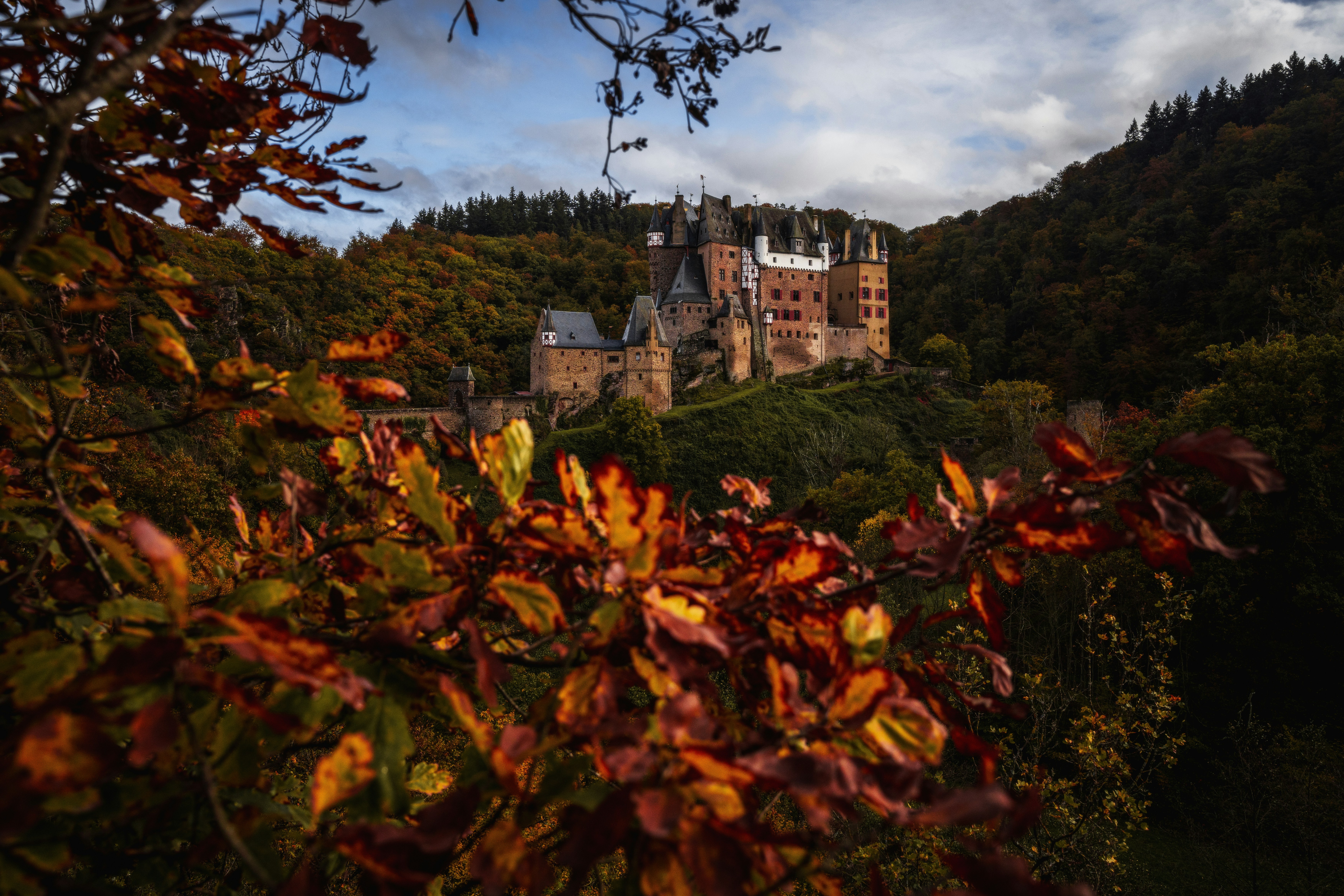 a large castle sitting on top of a lush green hillside
