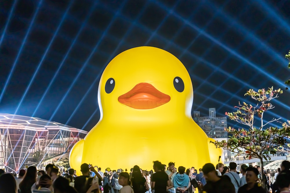 a crowd of people standing around a giant rubber duck