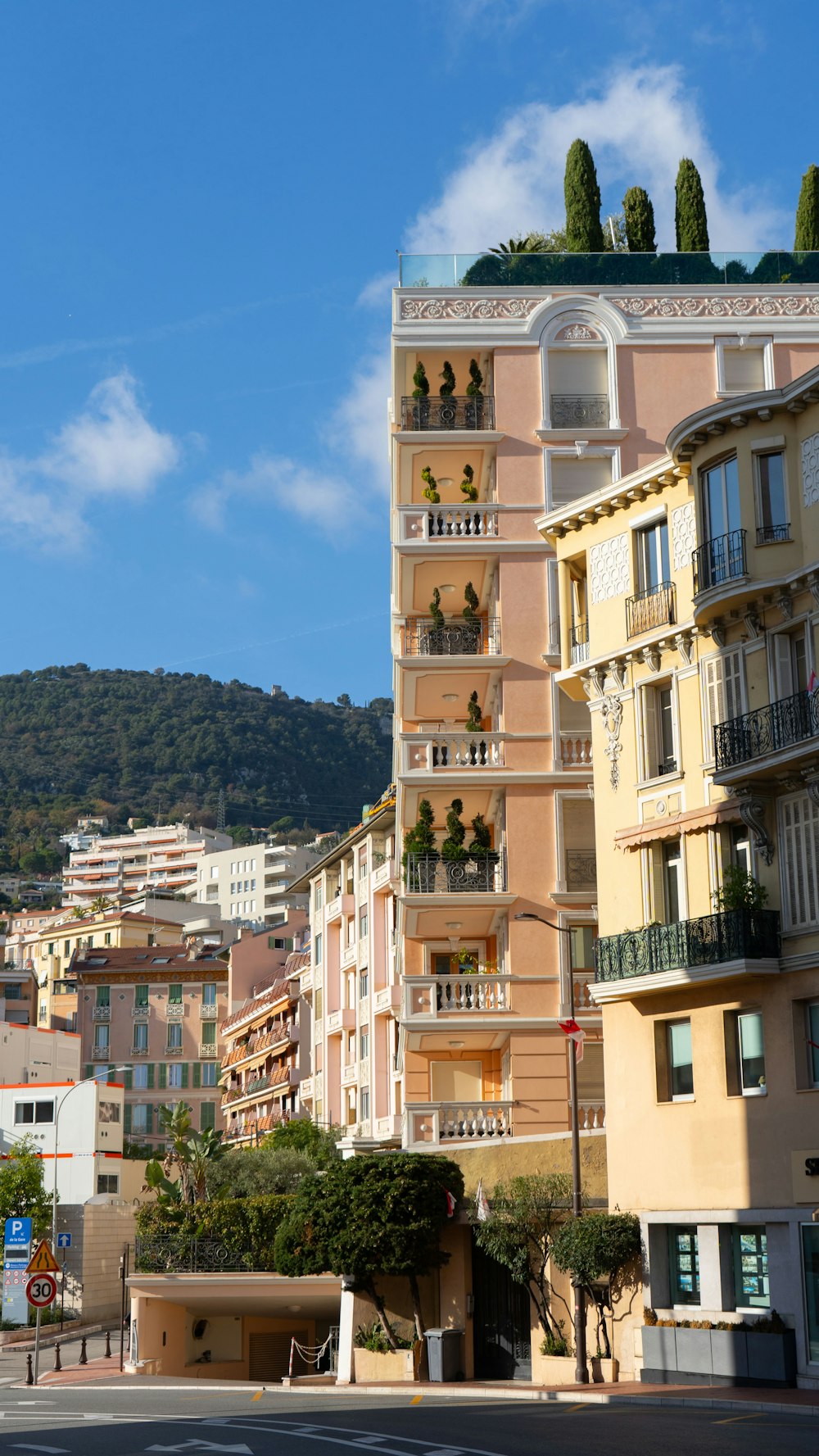 Una strada cittadina con alti edifici e una collina sullo sfondo