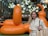 a woman is standing in front of an orange balloon