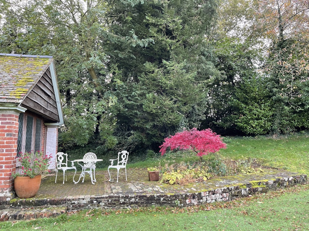 a patio with a table and chairs next to a tree