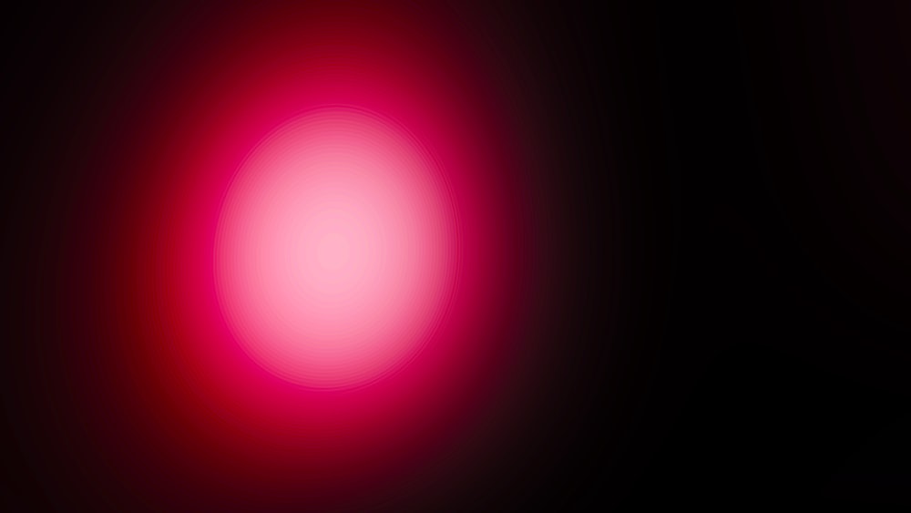 Ein verschwommenes Bild eines roten Lichts auf schwarzem Hintergrund