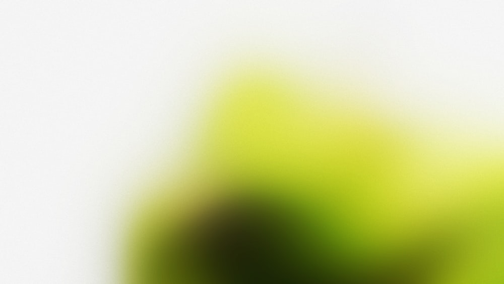 Ein verschwommenes Bild eines grünen Apfels auf weißem Hintergrund