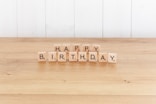 a wooden block spelling happy birthday on a table