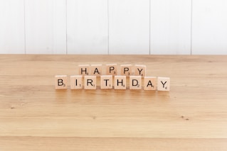 a wooden block spelling happy birthday on a table