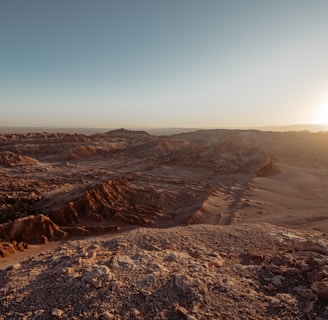 the sun is setting over a desert landscape