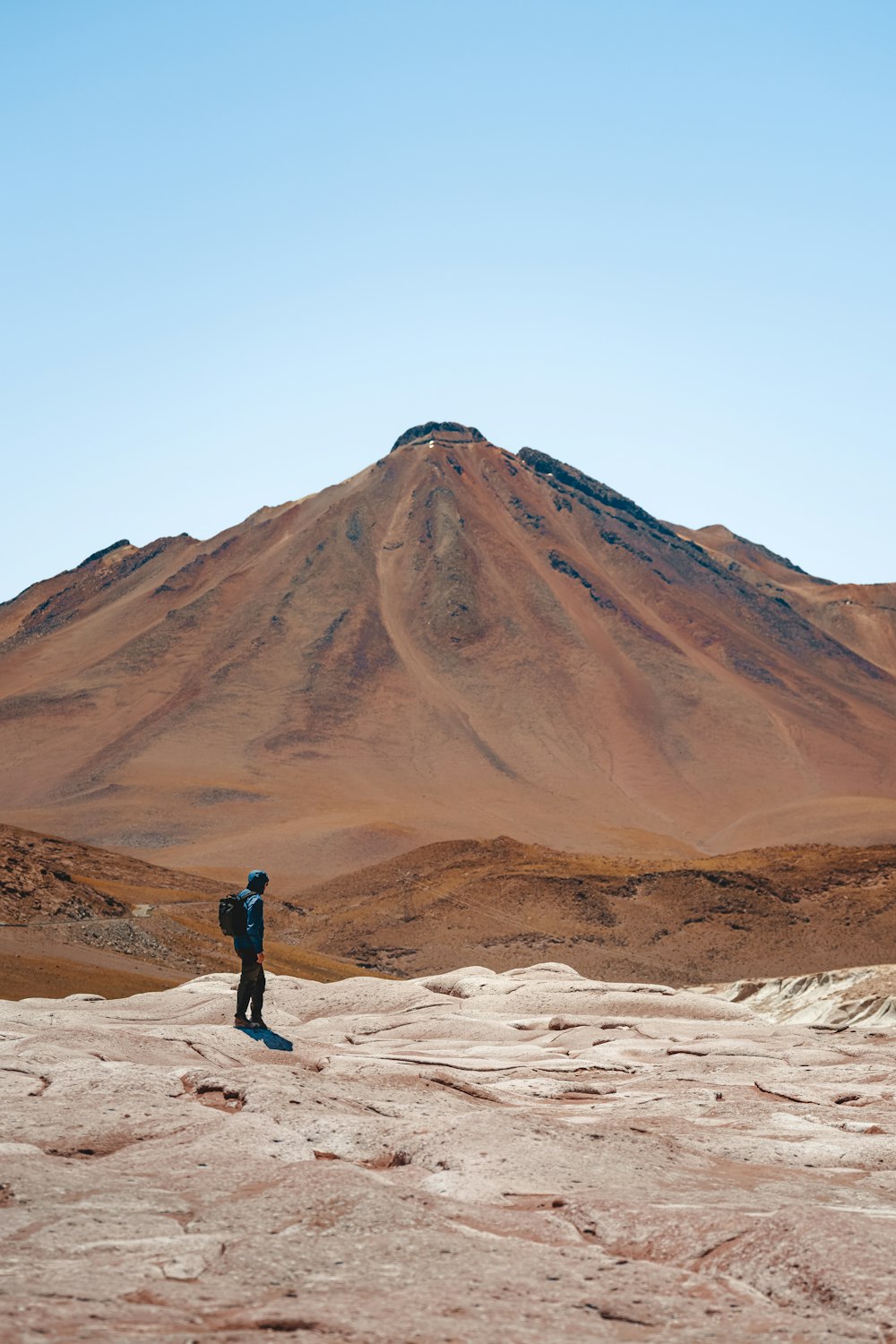 a man standing on top of a sandy hill