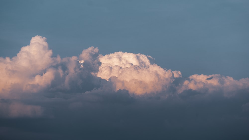 a plane flying in the sky with a lot of clouds