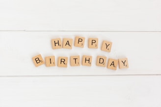 a happy birthday spelled with scrabbles on a white background