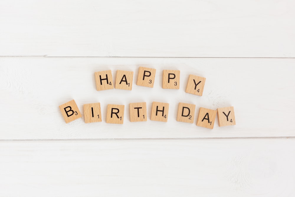 a happy birthday spelled with scrabbles on a white background