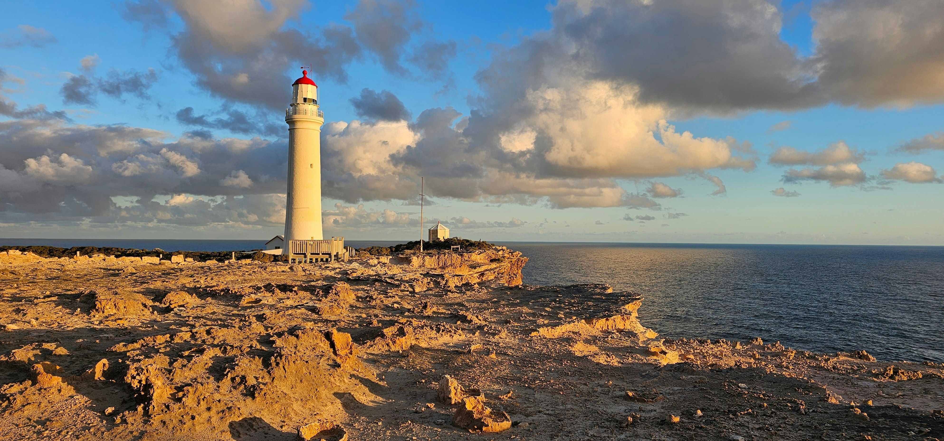 a light house sitting on top of a cliff next to the ocean