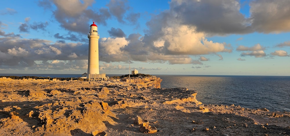 a light house sitting on top of a cliff next to the ocean