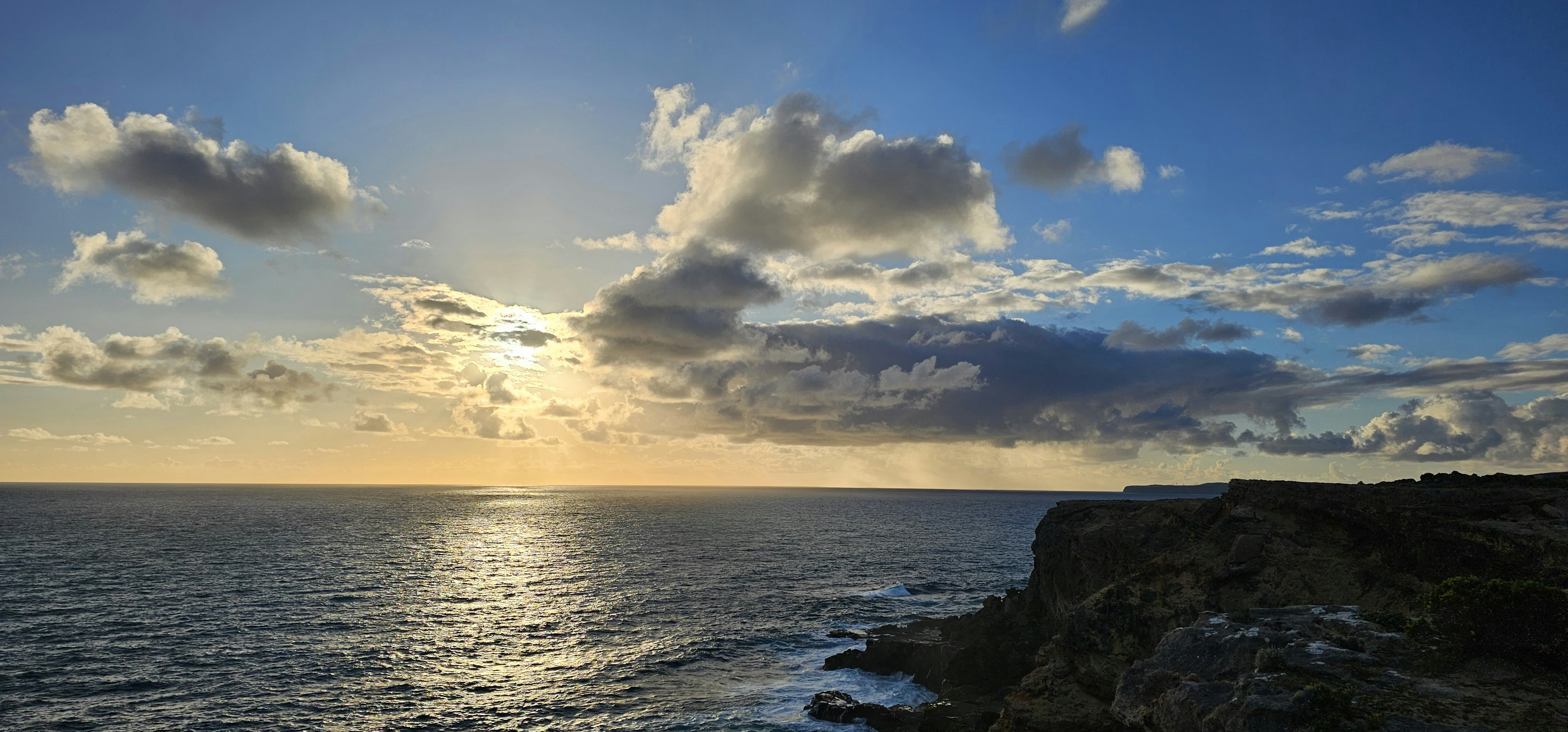 the sun is shining through the clouds over the ocean