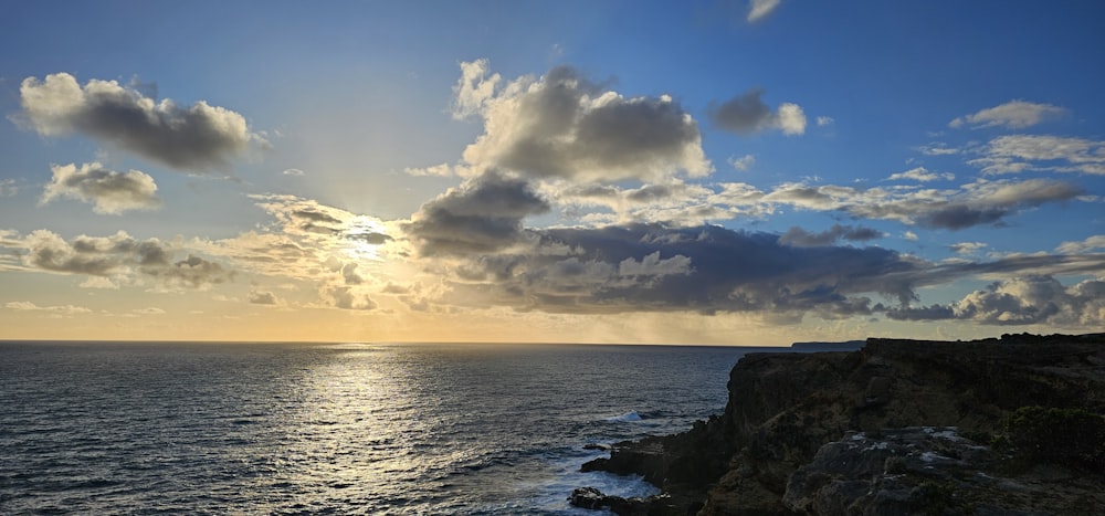 the sun is shining through the clouds over the ocean