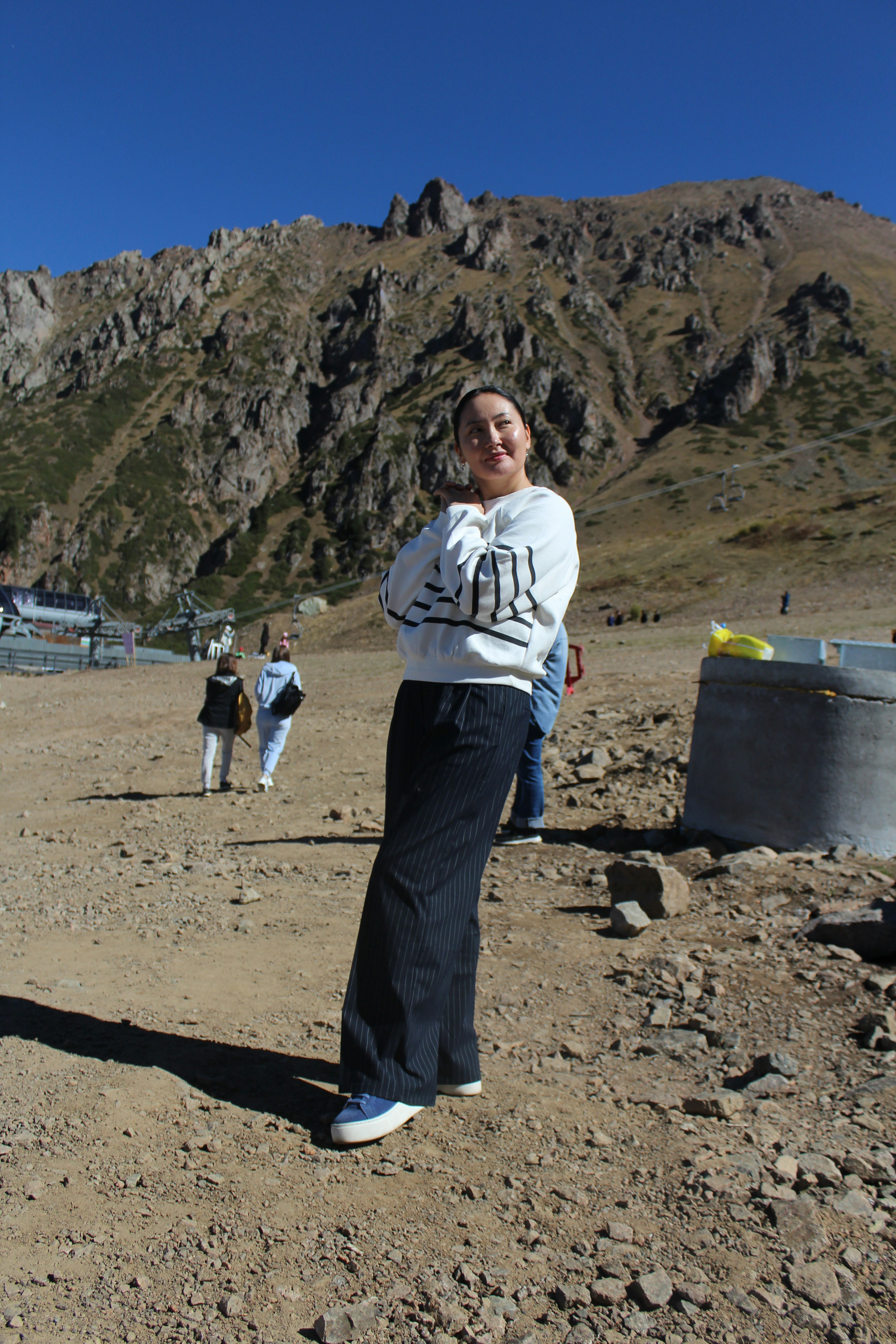 a woman standing on top of a dirt field