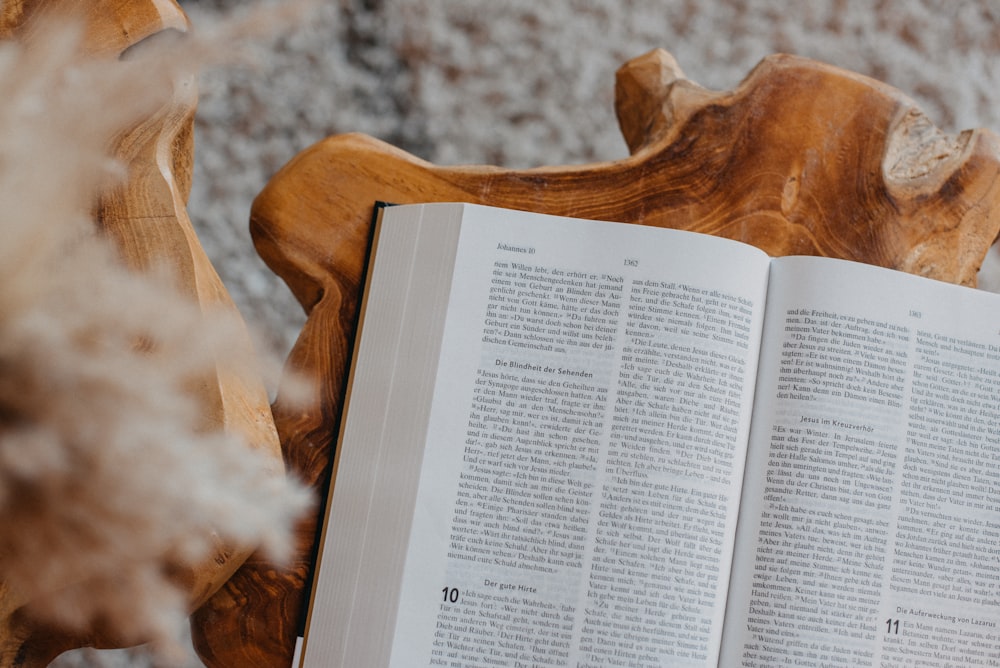 an open book sitting on top of a wooden bench