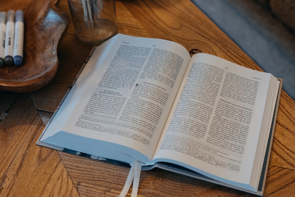 an open book sitting on top of a wooden table