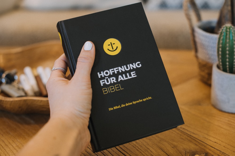 a person holding a book with a smiley face on it