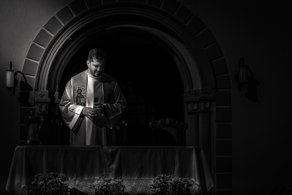 a black and white photo of a priest