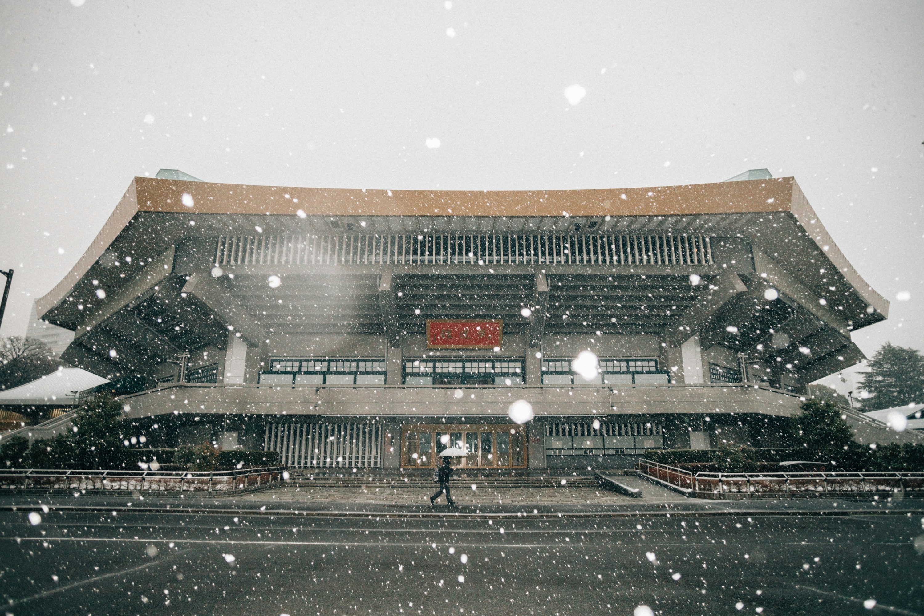 a person walking in front of a building in the snow