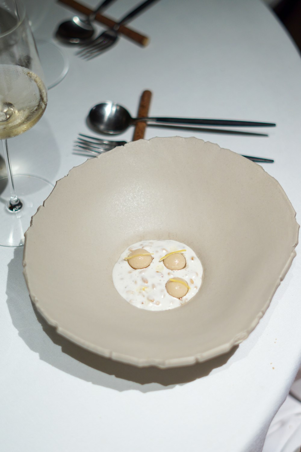 a white table topped with a bowl filled with food