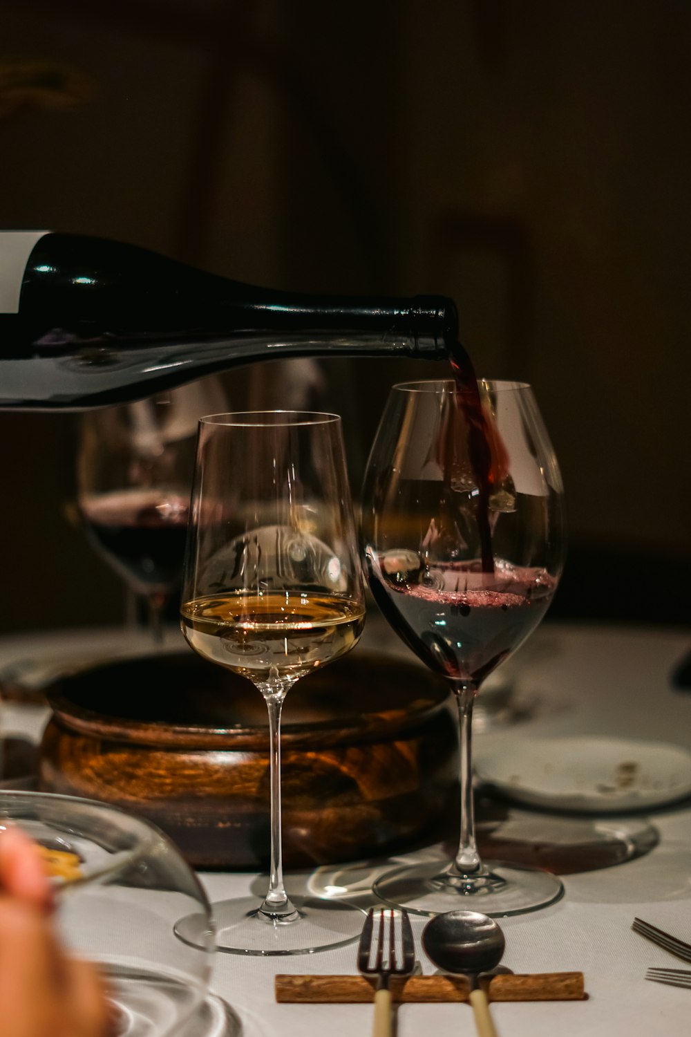 a person pouring a glass of wine into a wine glass