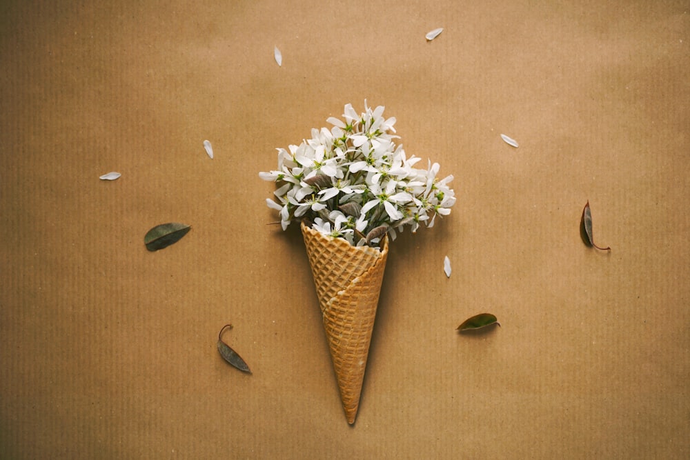 un cône avec un bouquet de fleurs à l’intérieur