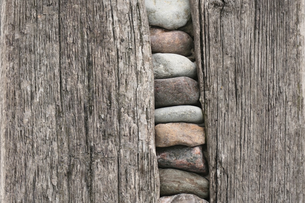 ein Haufen Steine, die in der Mitte eines Holzzauns sitzen
