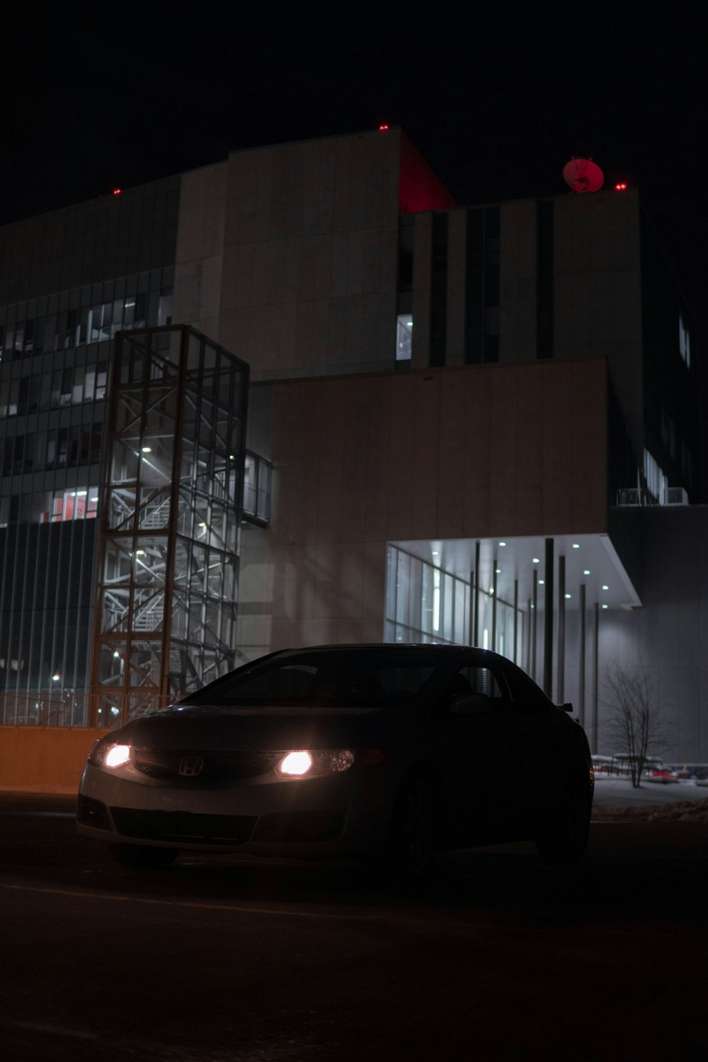 a car parked in front of a building at night