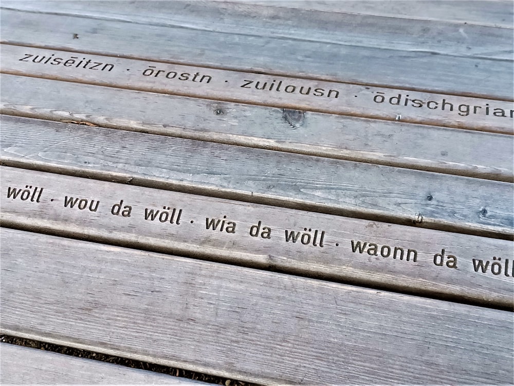 a close up of a wooden bench with writing on it