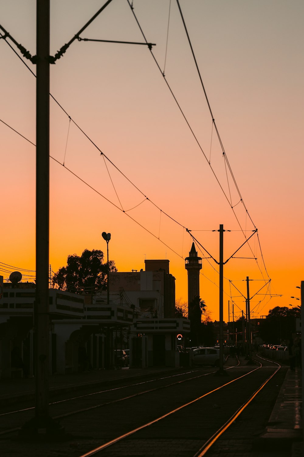 a train track with the sun setting in the background