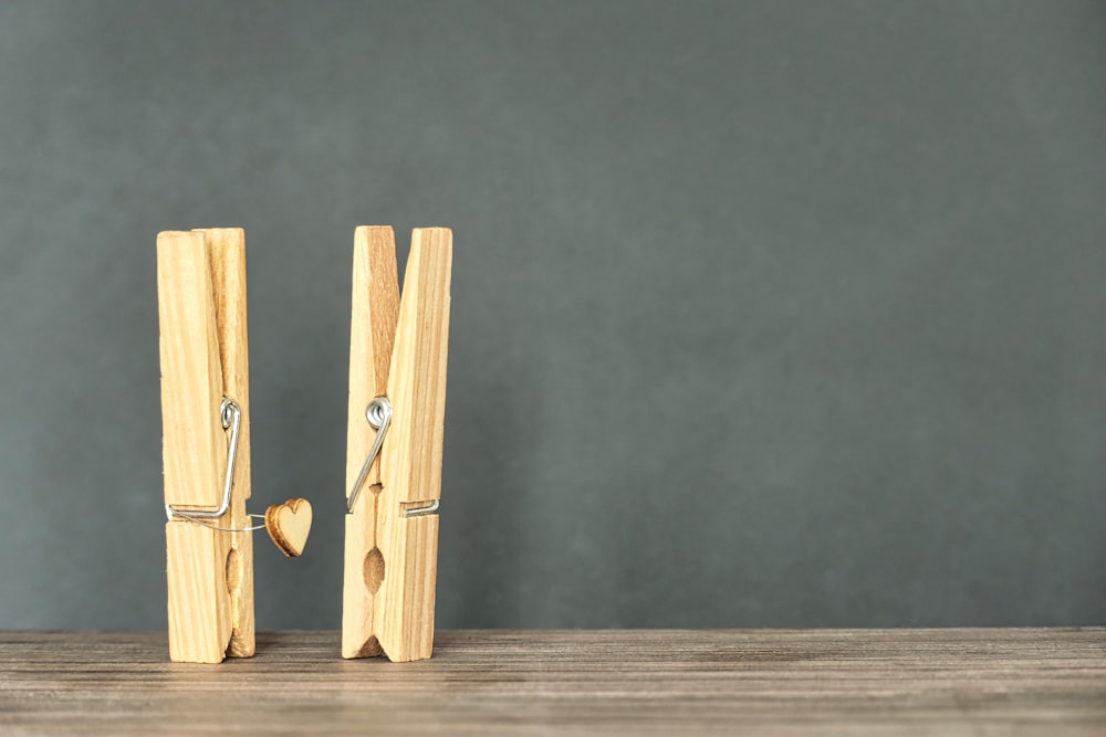 a pair of wooden pegs holding a heart