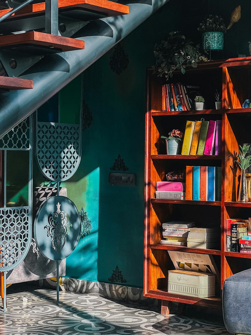 a bookshelf filled with lots of books next to a stair case