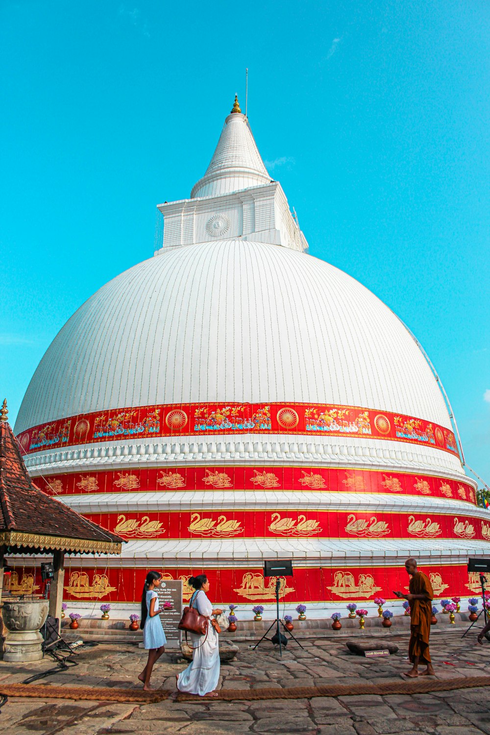 a group of people standing around a red and white building