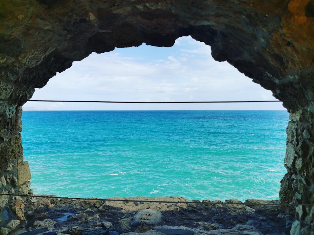 a view of a body of water from inside a cave