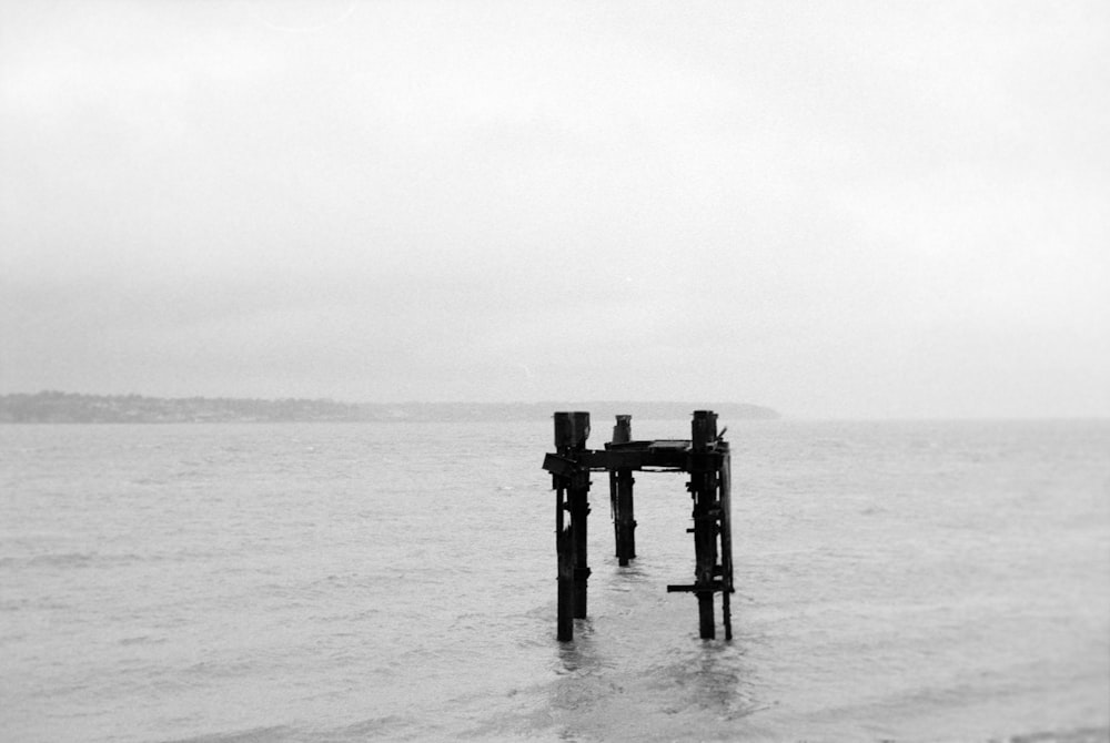 a black and white photo of a pier in the water