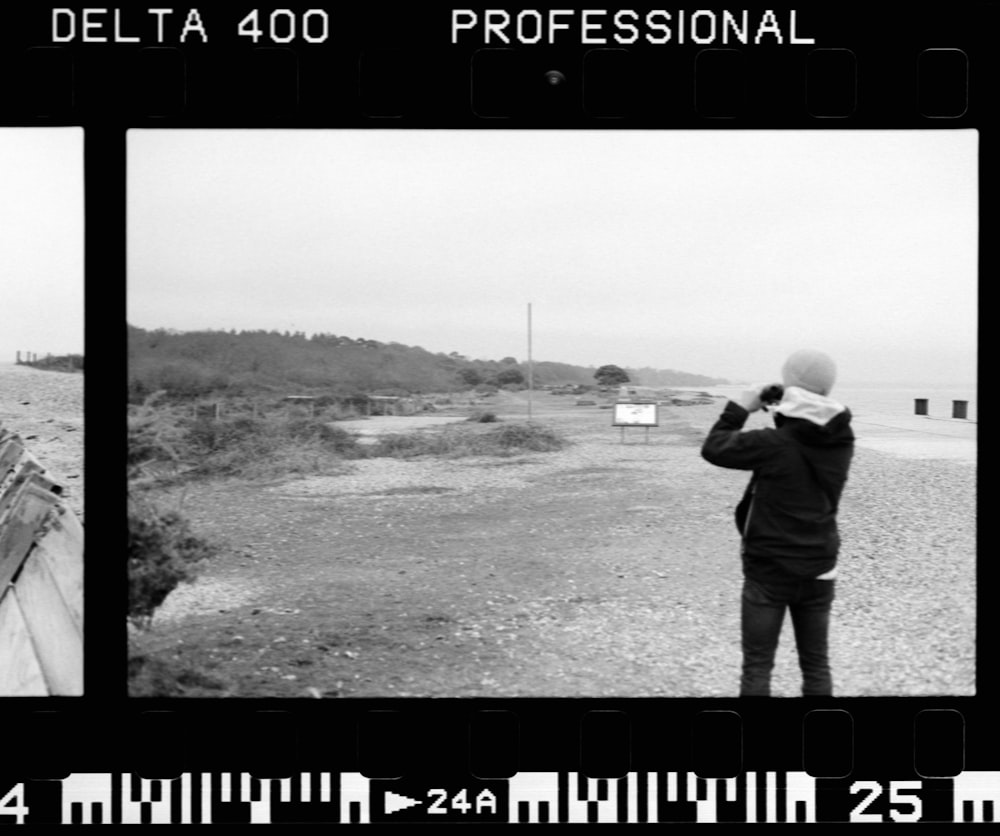 a black and white photo of a person flying a kite