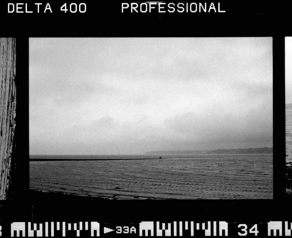 a black and white photo of a beach and ocean