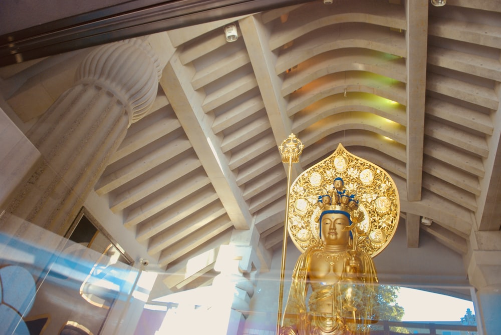 a golden buddha statue sitting inside of a building