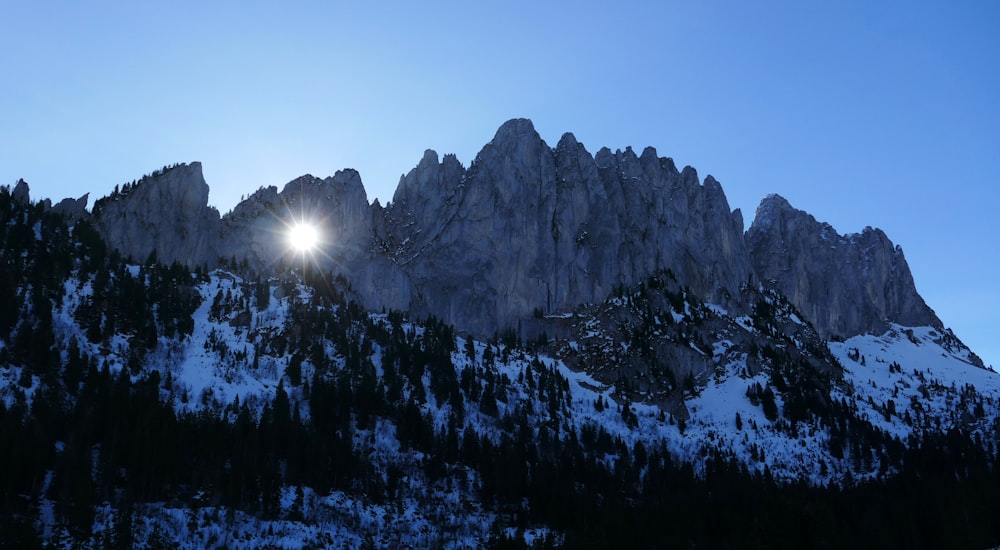 the sun shines brightly on a snowy mountain