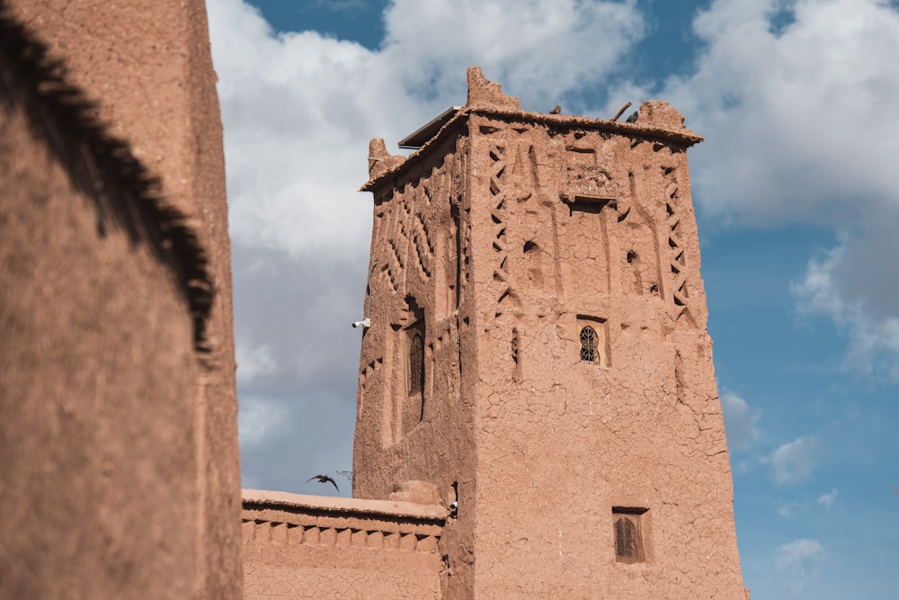 a tall brown building with a sky background