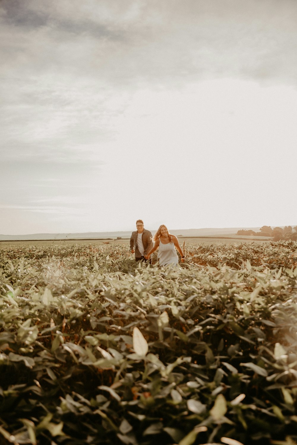 um homem e uma mulher caminhando por um campo