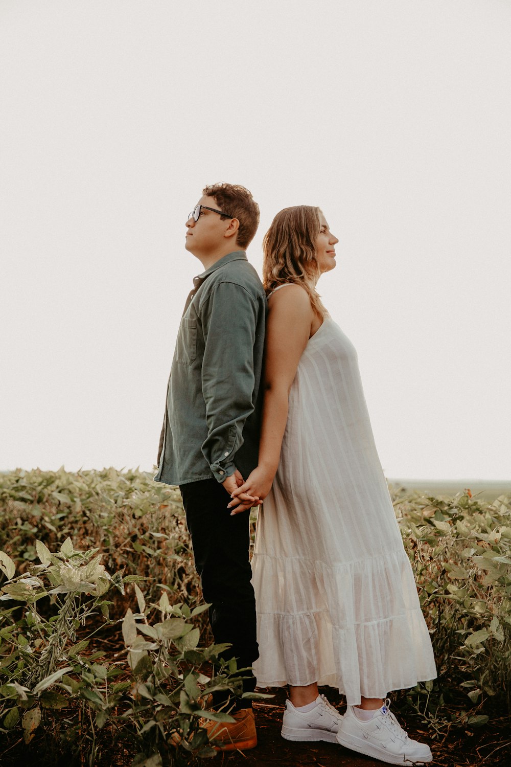 a man and a woman standing next to each other in a field