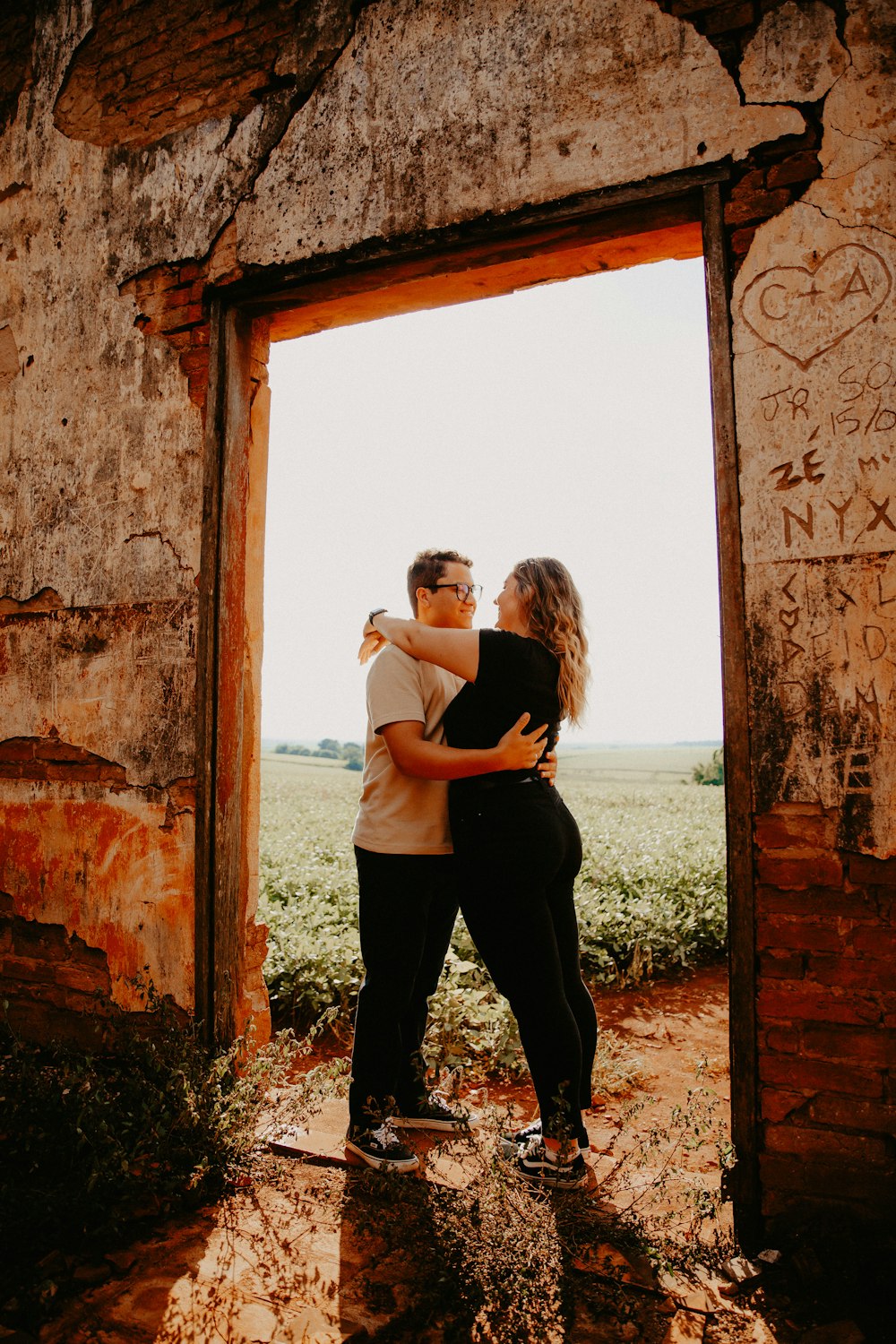 um homem e uma mulher abraçados em um prédio antigo