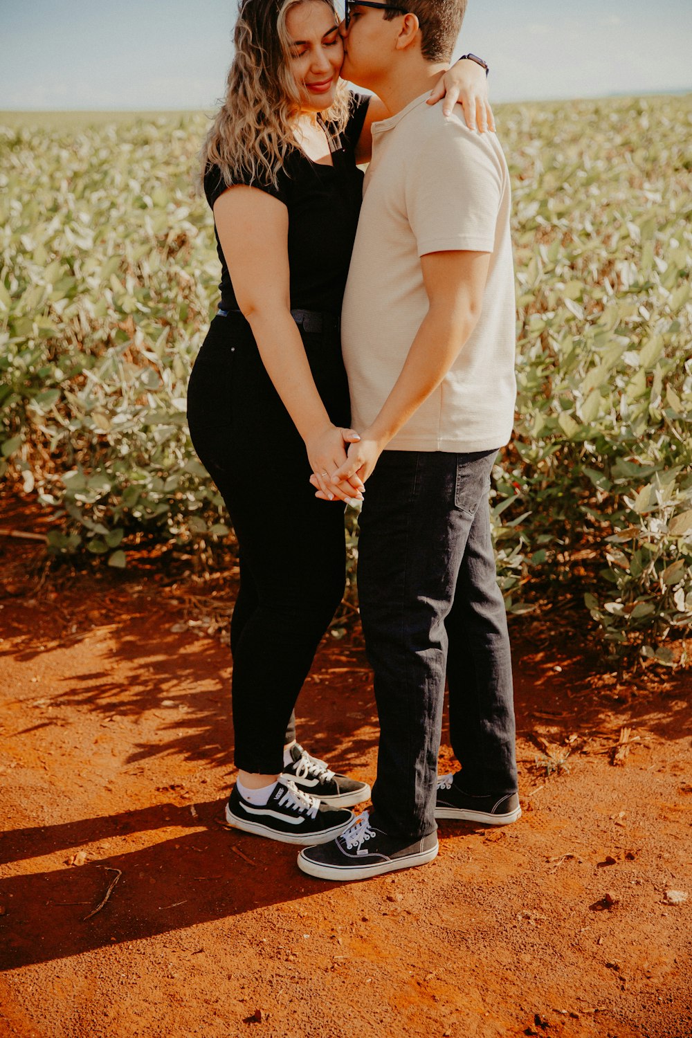 a man and a woman holding hands in a field