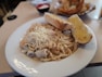 a white plate topped with pasta and meat